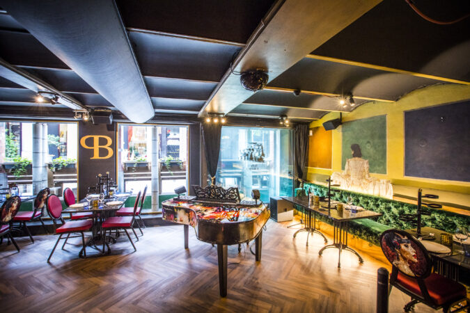 Restaurant met piano en donkere visgraat vloer in Amsterdam